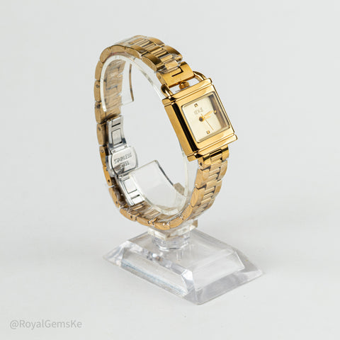 A gold-tone rectangular women's watch with a matching metal link bracelet, displayed on a clear acrylic stand against a light gray background.