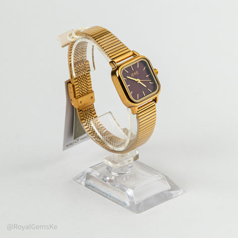 A vintage-style gold-tone watch with a square bezel and mesh band, displayed on a clear acrylic stand against a white background.