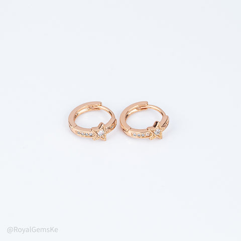 Pair of rose gold hoop earrings with small diamonds on a light gray background