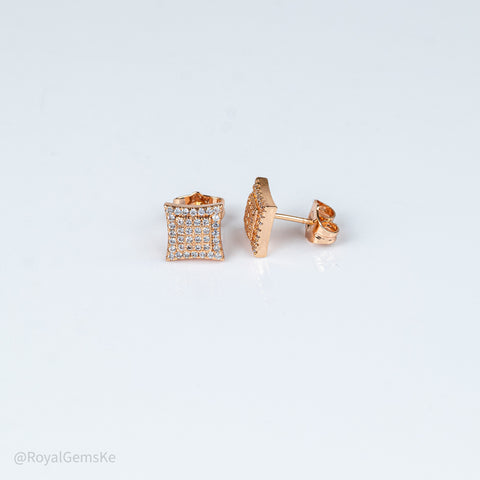 A pair of rose gold square stud earrings with a grid of small clear stones on one earring and a textured rose gold back on the other, displayed on a clean white background.