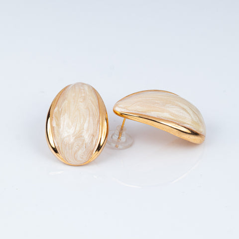 Pair of gold and beige earrings on a light gray background