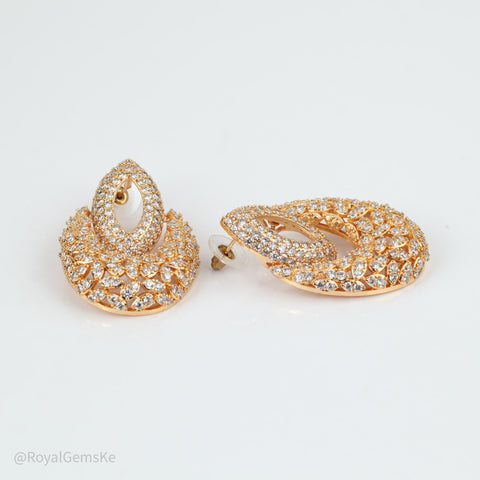 A pair of gold-toned teardrop-shaped earrings adorned with pavé-set clear crystals and a central white stone, displayed on a clean white background.