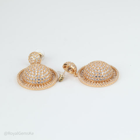 A pair of rose gold dome-shaped stud earrings paved with clear rhinestones, displayed on a clean white background.