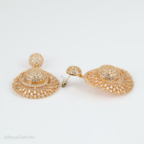 A pair of gold-toned statement earrings with intricate pavé crystal detailing, displayed on a clean white background.