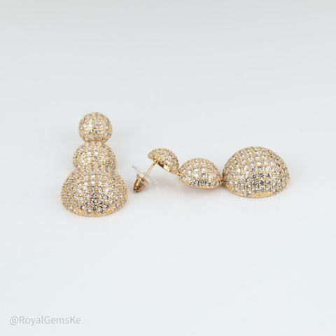 Gold-tone pavé dangle earrings with a three-blob drop design, displayed on a clean white background.