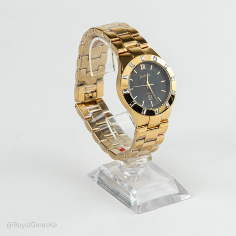 Gold-tone women's watch with a black dial and crystal-set bezel, displayed on a clear acrylic stand against a light gray background.