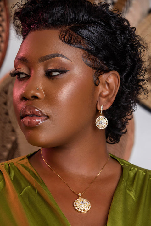 Woman wearing gold earrings and necklace with a blurred background
