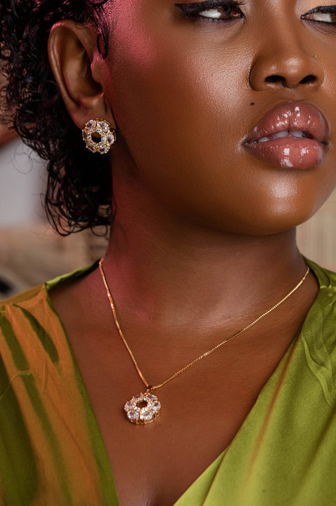 Close-up of a woman wearing gold jewelry with a blurred background