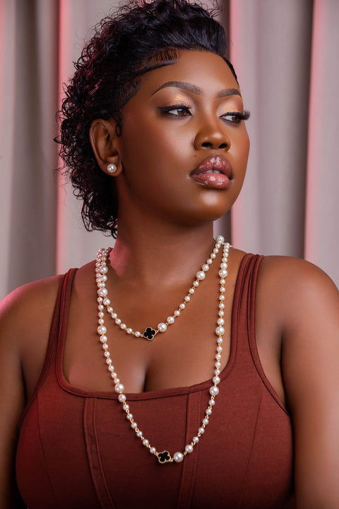Woman wearing a pearl necklace against a neutral background