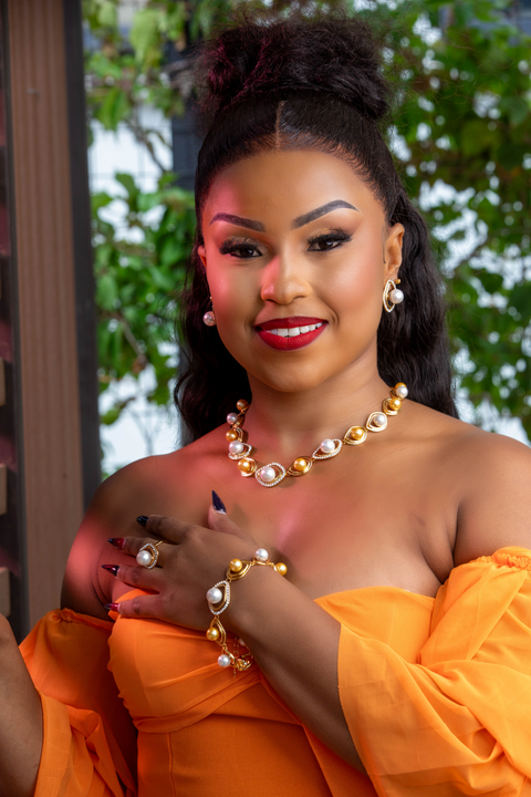 Woman in an orange outfit with jewelry, outdoors