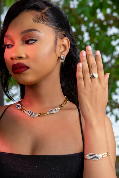 Woman wearing gold jewelry with a blurred green background
