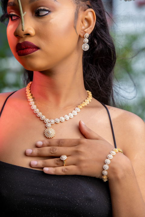Woman wearing a pearl necklace, ring, and bracelet with a blurred background