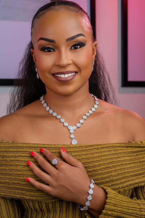 Woman wearing a necklace, ring, and bracelet with a blurred background