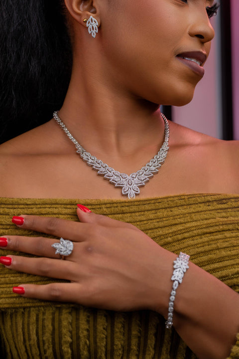 Woman wearing a diamond necklace, ring, and bracelet on a blurred background