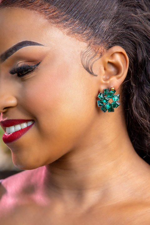 Close-up of a woman wearing green earrings with a blurred background