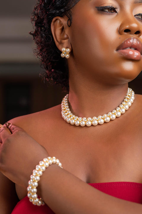 Woman wearing a pearl necklace and bracelet with a blurred background