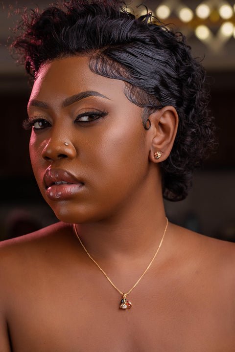 Woman with styled hair and a necklace against a blurred background